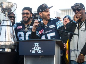 Toronto Argonauts quarterback Ricky Ray looks over at James Wilder Jr. as he speaks to fans gathered in Toronto's Nathan Phillips Square on Nov. 28, 2017