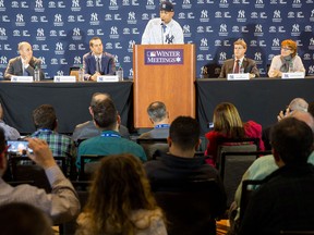New Yankees signing Giancarlo Stanton, centre, talks during the Major League Baseball winter meetings in Orlando on Dec. 11, 2017