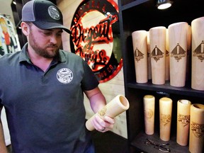 Kris Dehnert of Dugout Mugs looks over a mug shaped like the end of a bat at a trade show at the Major League Baseball winter meetings on Dec. 13, 2017