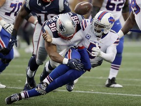 Buffalo Bills quarterback Tyrod Taylor fumbles as he is sacked by New England Patriots defensive end Trey Flowers (98) during the second half of an NFL football game, Sunday, Dec. 24, 2017, in Foxborough, Mass.