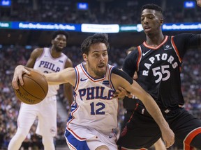 Philadelphia 76ers T.J. McConnell (left) drives at Toronto Raptors' Delon Wright during first half NBA basketball action in Toronto on Saturday, December 23, 2017. THE CANADIAN PRESS