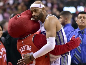 Sacramento Kings guard Vince Carter (15) embraces The Raptor, the Toronto Raptors mascot during second half NBA basketball action in Toronto on Sunday, December 17, 2017. THE CANADIAN PRESS/Frank Gunn