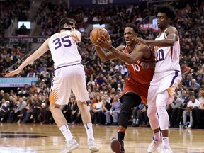 Toronto Raptors guard DeMar DeRozan (10) gets fouled as he drives to the net between Phoenix Suns forward Dragan Bender (35) and Josh Jackson (20) during second half NBA basketball action in Toronto on Tuesday, December 5, 2017. THE CANADIAN PRESS
