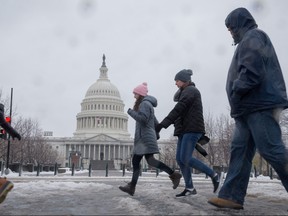 People walk the snow-covered streets near the US Capitol in Washington, D.C. on March 14, 2017. (TASOS KATOPODIS/AFP/Getty Images)