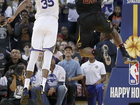 Golden State Warriors forward Kevin Durant (35) blocks Cleveland Cavaliers forward LeBron James (23) during the second half of an NBA basketball game in Oakland, Calif., Monday, Dec. 25, 2017. The Warriors won 99-92. The Associated Press