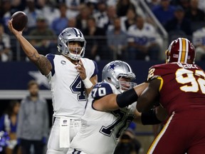 Dallas Cowboys quarterback Dak Prescott (4) throws a pass as guard Zack Martin (70) helps defend against a rush by Washington Redskins defensive tackle Stacy McGee (92) in the first half of an NFL football game, Thursday, Nov. 30, 2017, in Arlington, Texas. (AP Photo/Ron Jenkins)