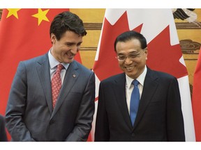 Canadian Prime Minister Justin Trudeau, left, and Chinese Premier Li Keqiang speak during a signing ceremony at the Great Hall of the People in Beijing Monday, Dec. 4, 2017. (Fred Dufour/Pool Photo via AP)