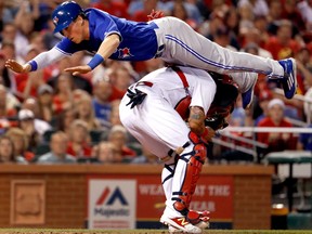 Toronto Blue Jays' Chris Coghlan leaps over St. Louis Cardinals catcher Yadier Molina to score on April 25, 2017