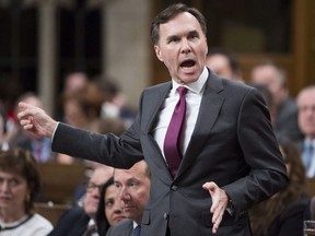 Minister of Finance Bill Morneau gestures for opposition MP's to repeat there questions outside the House of Commons during Question Period Thursday Nov.30, 2017 in Ottawa.