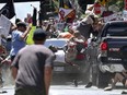In this Aug. 12, 2017 file photo, people fly into the air as a vehicle is driven into a group of protesters demonstrating against a white nationalist rally in Charlottesville, Va.
