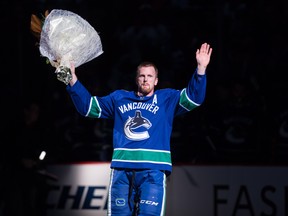 Vancouver Canucks’ Daniel Sedin, of Sweden, waves to the crowd as he’s honoured for recently recording his 1,000th career point before playing the Leafs last night. (The Canadian Press)
