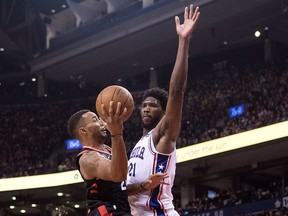 Toronto Raptors' Norman Powell (left) shoots on Philadelphia 76ers' Joel Embiid (right) during second half NBA basketball action in Toronto on Saturday, Dec. 23, 2017. THE CANADIAN PRESS/Chris Young