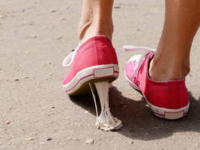 In this stock photo, a woman's shoe gets stuck in chewing gum on the street.