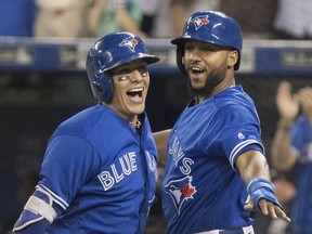 Toronto Blue Jays' Ryan Goins, left, celebrates his grand-slam against the New York Yankees with Richard Urena in the sixth inning in their American League MLB baseball game in Toronto on Friday, September 22, 2017. THE CANADIAN PRESS/Fred Thornhill