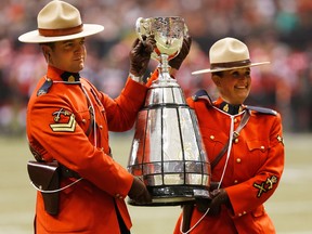 RCMP officers carry out the Grey Cup trophy during the 102nd Grey Cup at BC Place in Vancouver on Nov. 30, 2014