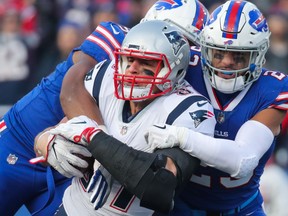 Preston Brown and Micah Hyde of the Buffalo Bills tackle Rob Gronkowski of the New England Patriots December 3, 2017 at New Era Field in Orchard Park, New York.