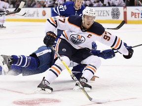 Edmonton Oilers centre Connor McDavid (97) drives to the net past sprawling Toronto Maple Leafs defenceman Ron Hainsey (2) during first period NHL hockey action in Toronto on Sunday, December 10, 2017. THE CANADIAN PRESS/Frank Gunn