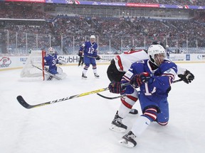 The United States' Kailer Yamamoto, right, battles with Canada's Dillon Dube during first period IIHF World Junior Championship preliminary outdoor game action at New Era Field in Orchard Park, N.Y., Friday, December 29, 2017.