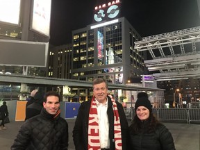 Mayor John Tory, wearing his TFC scarf, with Sam Sniderman’s grandchildren in Yonge-Dundas Square with the newly-lit Sam the Record Man sign in the background on Friday, Dec. 8, 2017.