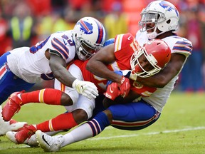 Running back Akeem Hunt, middle, of the Kansas City Chiefs is tackled by Ramon Humber #50 and teammate defensive end Jerry Hughes #55 of the Buffalo Bills during the second half at Arrowhead Stadium on November 26, 2017 in Kansas City, Missouri. (Peter Aiken/Getty Images )