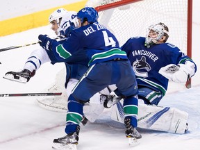 Vancouver Canucks defenceman Michael Del Zotto (4) checks Toronto Maple Leafs forward Nazem Kadri, left, in front of Vancouver goalie Jacob Markstrom, right, in Vancouver, B.C., on Saturday December 2, 2017.