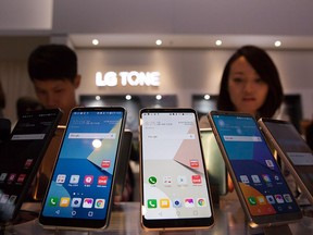 Visitors look at LG V30 smartphones at the LG stand at the 2017 IFA consumer electronics and home appliances trade fair on Sept. 1, 2017 in Berlin, Germany. (Michele Tantussi/Getty Images)