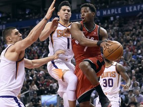 Phoenix Suns centre Alex Len and Devin Booker defend as Toronto Raptors guard Kyle Lowry looks for the pass on Dec. 5, 2017