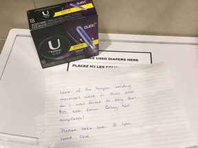 An anonymous note and a $15 box of tampons is shown in a women's washroom at the Calgary International Airport on Nov. 26, 2017. Though many shocked at the price, women in remote Indigenous communities often pay that much or more for feminine hygiene products, according to the organization Moon Time Sisters. THE CANADIAN PRESS/HO-Carlee Field MANDATORY CREDIT