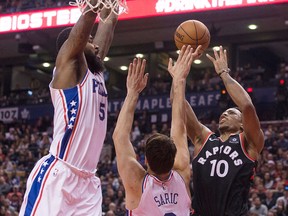 Toronto Raptors' DeMar DeRozan (right) shoots over Philadelphia 76ers Dario Saric and Amir Johnson (left) during first half NBA basketball action in Toronto on Saturday, Dec. 23, 2017. THE CANADIAN PRESS/Chris Young