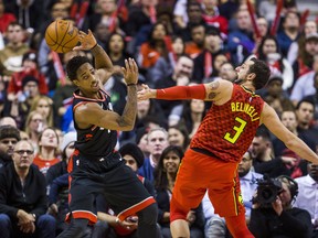Raptors' DeMar DeRozan looks to make a pass against the Hawks' Marco Belinelli at the Air Canada Centre on Friday night. (Ernest Doroszuk/Toronto Sun/Postmedia Network)