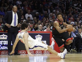 Los Angeles Clippers' Milos Teodosic, left, takes a tumble while defending Toronto Raptors' Kyle Lowry during the second half of an NBA basketball game Monday, Dec. 11, 2017, in Los Angeles. The Clippers won 96-91. The Associated Press