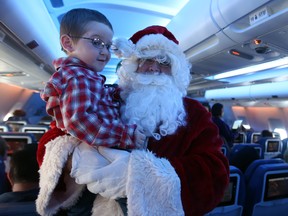 Christian Bellefeuille,4, gets lifted by Santa himself during the Flight in Search of Santa organized by Air Transat in Toronto on Wednesday, Dec. 6, 2017. (DAVE ABEL/TORONTO SUN)