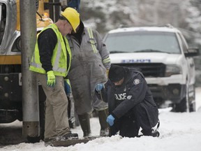 Toronto Police Forensics Det. Richard Weller and City of Toronto workers search under sewer grates for anything that could be connected to the investigation into the deaths of Honey and Barry Sherman at their home on Old Colony Rd. in Toronto, on Saturday, Dec. 23, 2017.
