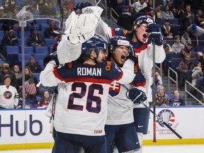 Slovakia players, left to right, goalie Roman Durny (obscured) Milos Roman, Martin Bodak, and Samuel Bucek celebrate defeating USA in IIHF World Junior Championship preliminary action in Buffalo, N.Y. Thursday December 28, 2017. THE CANADIAN PRESS/Mark Blinch