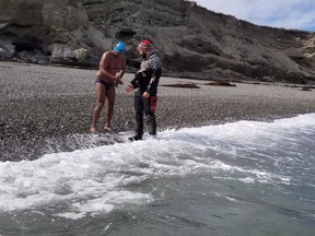 Madhu Nagaraja, 47, shakes hand with a safety scuba diver after swimming the Strait of Magellan, in Punta Arenas, Chile, in a Nov. 29, 2017, handout image.