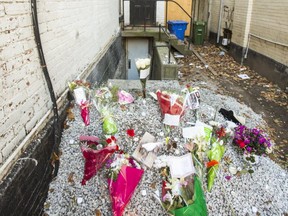 A make-shift memorial of flowers and birthday cards outside the abandoned building near Church and Wellesley Sts. in Toronto, Ont., where murder victim Tess Richey was found on Saturday, Dec. 2, 2017.