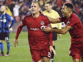 Toronto FC midfielder Benoit Cheyrou celebrates his goal against the Montreal Impact with teammate Justin Morrow on Nov. 30, 2016