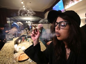 Employee Emily Walsh smokes marijuana at retail outlet Cannabis Culture in downtown Toronto  on March 10, 2017.