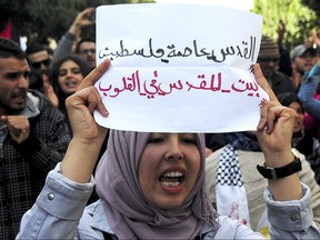 A Tunisian demonstrator holds a poster reading "Jerusalem Palestine capital. Jerusalem is in our heart" during a protest in Tunis, Thursday, Dec.7, 2017. The demonstration has been called against U.S President Donald Trump administration's decision to recognize Jerusalem as Israel's capital. (AP Photo/Hassene Dridi)