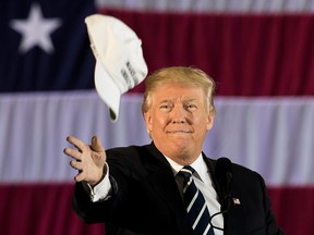 Donald Trump tosses a "Make America Great Again" hat into the crowd while speaking at the Dow Chemical Hangar, Dec. 9, 2016 in Baton Rouge, La.  (Drew Angerer/Getty Images)