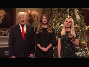 Scarlett Johansson as Ivanka Trump (left) holds a Christmas ornament of Roy Moore next to Alec Baldwin's Donald Trump  and Cecily Strong's Melania Trump on "Saturday Night Live." (Video screenshot)