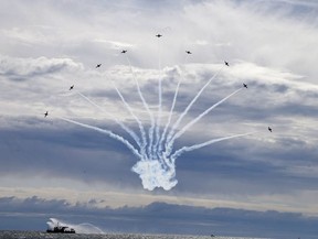 Snowbirds spread out above the Toronto fireboat on day one of the Canadian International Air Show at the the CNE in Toronto on Saturday, Sept. 2, 2017.