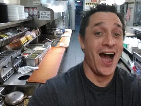 In this image taken early Thursday, Nov. 30, 2017, Alex Bowen poses in the kitchen at a Waffle House in West Columbia, S.C. When Bowen found the only worker at the empty South Carolina Waffle House asleep, he took his meal into his own hands. Bowen chronicled with selfies how he made his own double Texas bacon cheese steak melt on Facebook