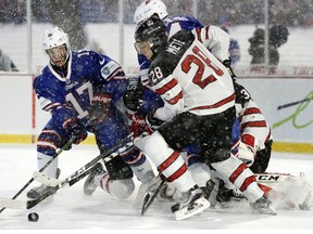 United States forward Kailer Yamamoto (17) and Canada defender Victor Mete (28) reach for the puck during the second period of a preliminary round hockey game of the IIHF World Junior Championship in Orchard Park, N.Y., Friday, Dec. 29, 2017.