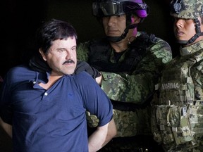 In this Jan. 8, 2016 file photo, a handcuffed Joaquin "El Chapo" Guzman is made to face the press as he is escorted to a helicopter by Mexican soldiers and marines at a federal hangar in Mexico City. (AP Photo/Eduardo Verdugo)