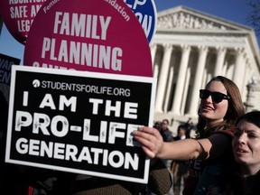 WASHINGTON, DC - JANUARY 19:  A pro-life activist tries to block the signs of pro-choice activists in front of the the U.S. Supreme Court during the 2018 March for Life January 19, 2018 in Washington, DC. Activists gathered in the nation's capital for the annual event to mark the anniversary of the Supreme Court Roe v. Wade ruling that legalized abortion in 1973.