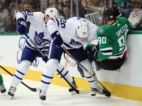 Jason Spezza of the Stars  gets knocked to the ice by Leafs Dominic Moore while Travis Dermott collects the loose puck Thursday night in Dallas. (Photo by Ronald Martinez/Getty Images)