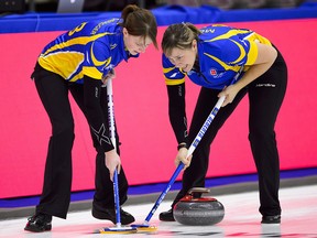 Alberta second Jesse Scheidegger, left , and lead Kristie Moore sweep as they take on Newfoundland at the Scotties Tournament of Hearts in Penticton, B.C., on Monday, Jan. 29, 2018. (THE CANADIAN PRESS/Sean Kilpatrick)