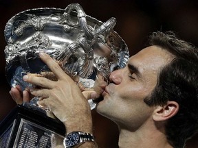 Switzerland's Roger Federer holds his trophy aloft after defeating Croatia's Marin Cilic during the men's singles final at the Australian Open tennis championships in Melbourne, Australia, Sunday, Jan. 28, 2018.