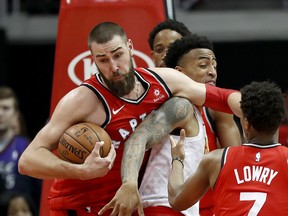 Toronto Raptors' Jonas Valanciunas, left, of Lithuania, grabs a rebound from Atlanta Hawks' John Collins during the third quarter of an NBA basketball game in Atlanta, Wednesday, Jan. 24, 2018. Toronto won 108-93. The Associated Press